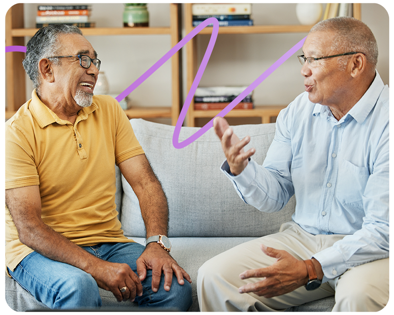 Image of two elderly men sitting on a sofa talking